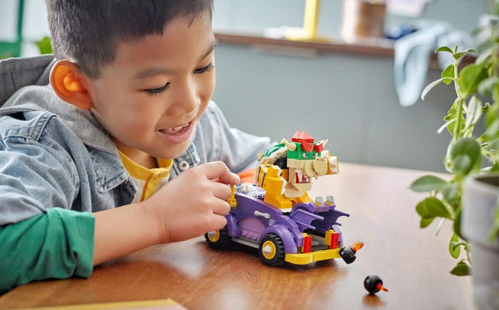Niño jugando con el set del muscle car de Bowser de LEGO Super Mario