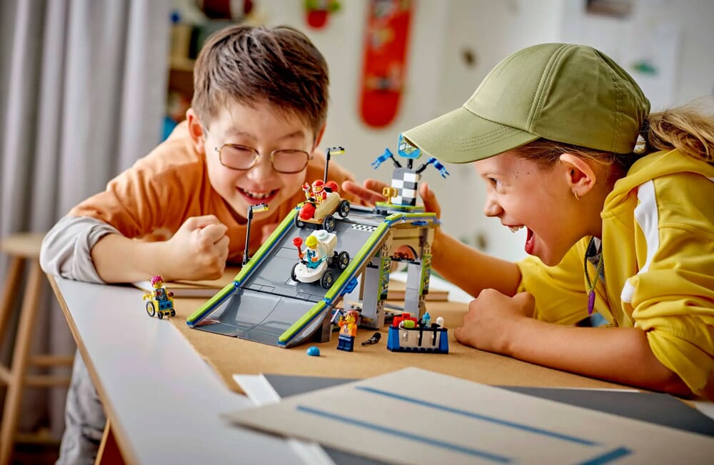 Dzieci bawiące się zestawem LEGO z rampą dla samochodu wyścigowego i wyrzutnią oraz minifigurkami