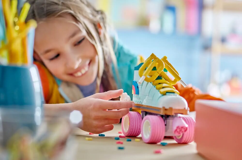 Dziewczynka bawiąca się wrotką LEGO Creator 3-w-1 z różowymi kółkami i żółtymi sznurówkami